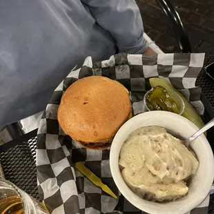 a hamburger with a side of mashed potatoes