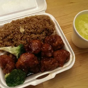 a take out container with rice and broccoli