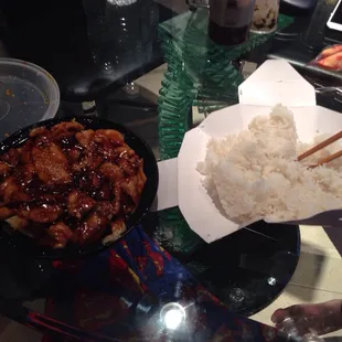 a bowl of rice and a bowl of chicken with chopsticks