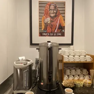 a coffee maker and cups of coffee