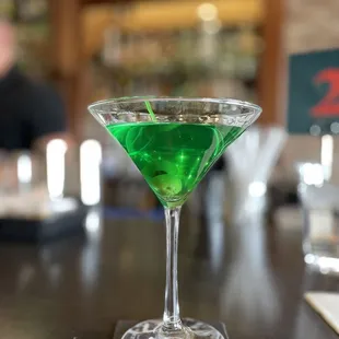 a green cocktail in a martini glass