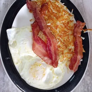 Southern style breakfast with fried eggs, hash browns and bacon