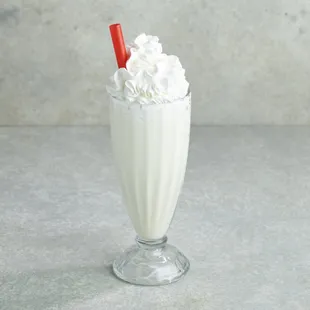 a milkshake with whipped cream and a red straw