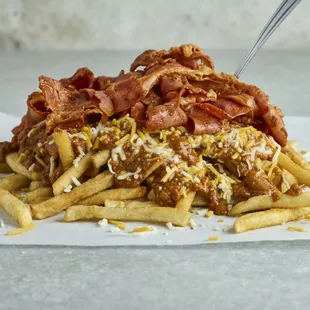a pile of french fries with bacon and cheese