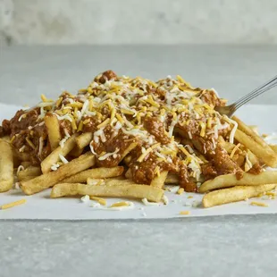 a pile of french fries topped with chili and cheese