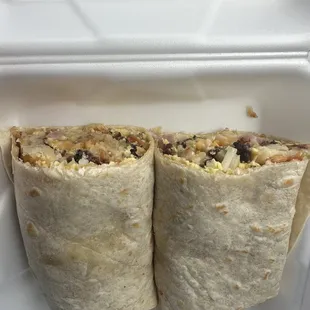 two burritos in a styrofoam container