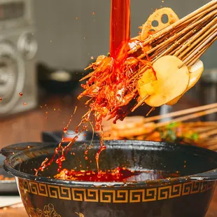 red sauce being poured over a bowl