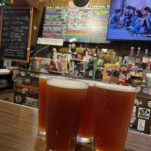 two glasses of beer on a bar