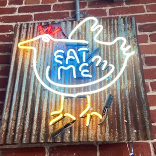 a neon sign on a brick wall