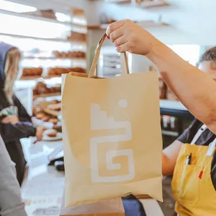 a woman holding a bag of bread