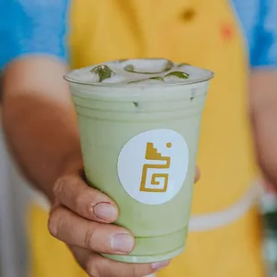 a person holding a cup of green tea