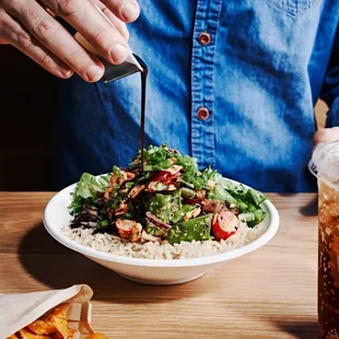 a man eating a salad and a drink