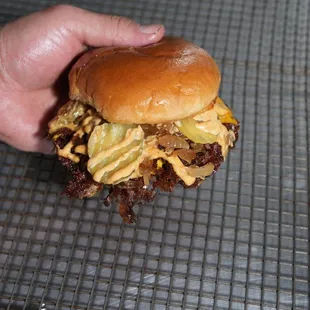 a hand holding a hamburger