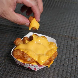 a hand holding a piece of cheese