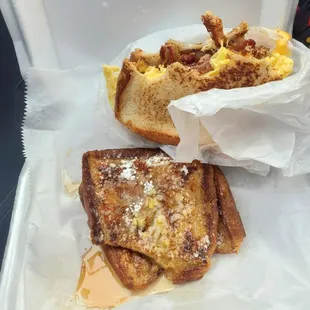 a sandwich and french toast in a styrofoam container