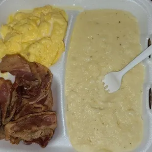 a tray of food with eggs, bacon, and bread