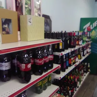 A few lost boxed dolls above the 2 lt. bottles and wines