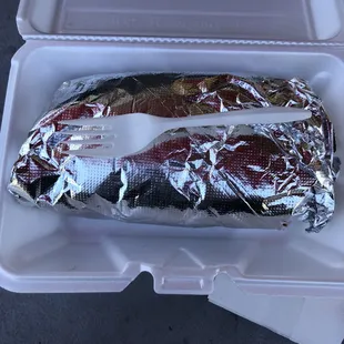 Still wrapped Chicken Burrito showing it's size, fork for scale.  Pretty darn big!