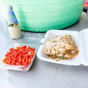 a plate of quesadillas and a container of tomatoes