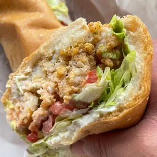 a hand holding a sandwich