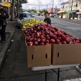 a man standing in front of a carton of apples