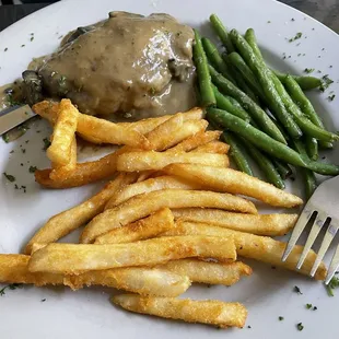 Chicken with gravy, green beans and French fries.
