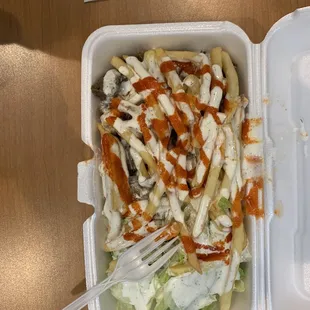 Beef platter, fries and hot sauce on top, rice and salad on bottom