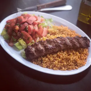 Lamb Adana Kebab served with bulgur wheat rice and salad