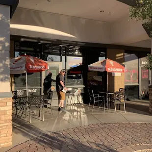 two people standing outside a restaurant