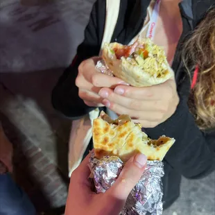 a woman holding a half eaten sandwich