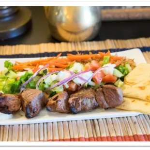 Lamb Kabab plate, Juicy tender Lamb grilled to perfection and served with rice, salad and pita, enjoy