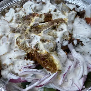 a plate of food with meat, onions, and gravy