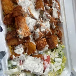 a chicken salad and fries in a styrofoam container