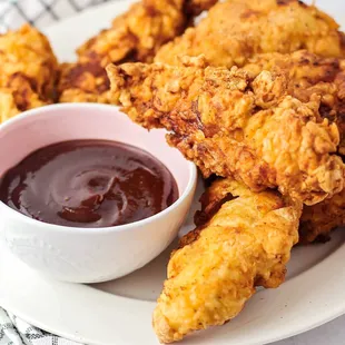 a plate of fried chicken with dipping sauce