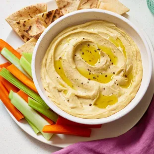 a bowl of hummus and carrots