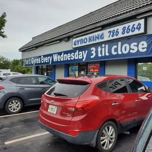a red car parked in front of a store
