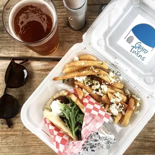 a container of food and a glass of beer