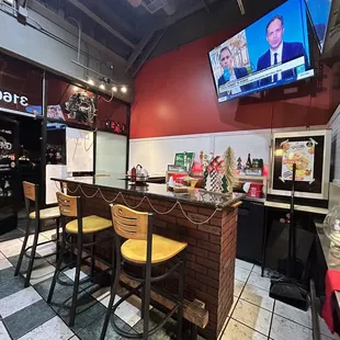 a bar with chairs and a television