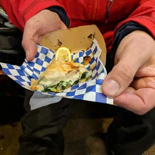 a person holding a sandwich