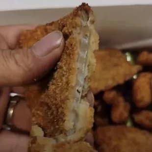 a hand holding a half eaten sandwich