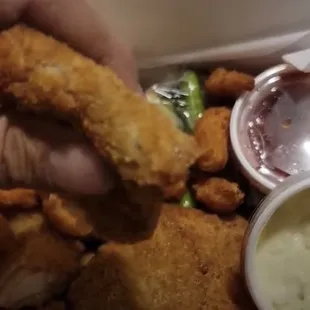 a hand holding a fried chicken sandwich