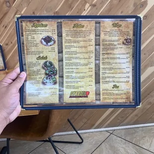 a hand holding a menu