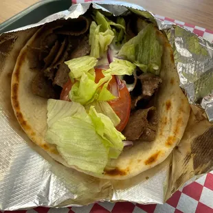 a pita filled with meat, lettuce and tomatoes