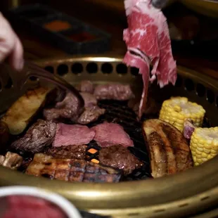 a person cutting meat on a grill