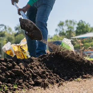 a man digging a pile of dirt
