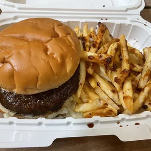 a hamburger and fries in a styrofoam container
