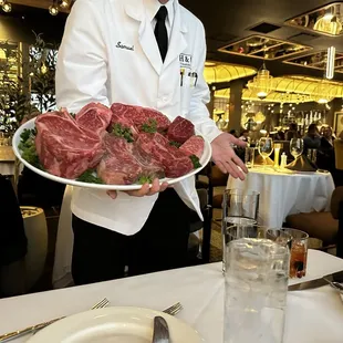 a man holding a plate of meat