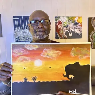 Budding Artist shows off his first painting in front of his new personal home gallary