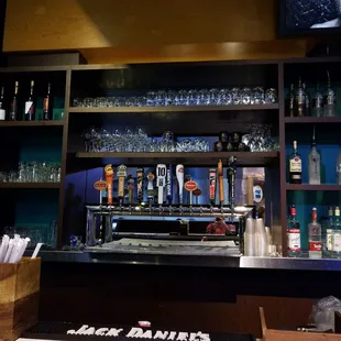 a bar with liquor bottles and a television