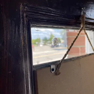 Original window glass with damage (left side of the rope) from a bank robbery